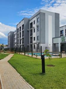 a large building with a swimming pool in a park at Otgreen suites in Gaborone
