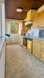 a large kitchen with wooden cabinets and a tile floor at Worker's Dream Apartment in Kirchenlamitz +26 photos