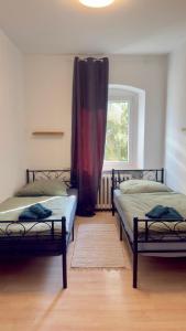 two beds in a room with a window at Worker's Dream Apartment in Kirchenlamitz