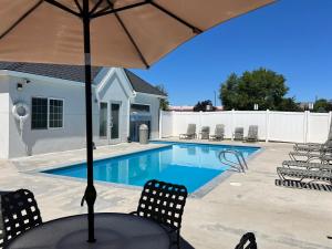 a table with an umbrella next to a swimming pool at Microtel Inn & Suites by Wyndham Klamath Falls in Klamath Falls