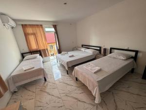 a room with three beds and a window at Chocolate in Ureki
