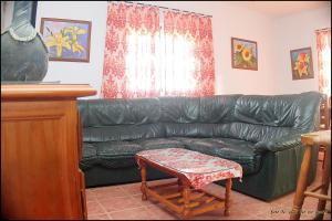 un sofá de cuero negro en la sala de estar en Mi Oasis, en Conil de la Frontera
