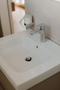 a white bathroom sink with a faucet at Natururlaub by Klotz TINY HAUS c in Überlingen