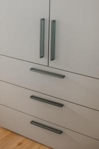 a white drawer with three black handles on it at Natururlaub by Klotz TINY HAUS c in Überlingen