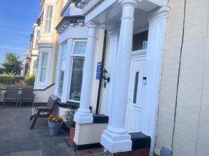 a white house with white columns and a door at Seaview Inn in Southport