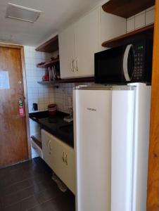a kitchen with a refrigerator and a microwave at Flat Encanto Baiano in Salvador