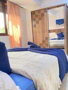 a bedroom with a bed and a mirror at Agadir City Appartement in Agadir