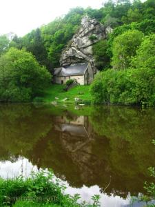 a house on a hill next to a body of water at Le clos de Tallann in Guénin