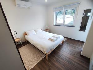 a small bedroom with a bed and a window at Cascais, Family retreat in a 2-bedroom apartment in Alcabideche