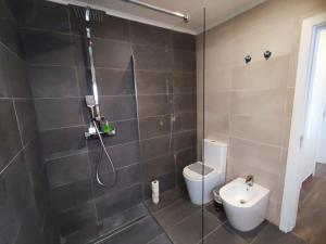 a bathroom with a shower with a toilet and a sink at Cascais, Family retreat in a 2-bedroom apartment in Alcabideche +11 photos