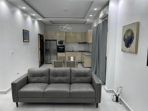 a living room with a couch and a kitchen at Résidence MuHamin in Ngaparou +20 photos