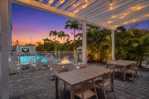 a patio with tables and chairs and a pool at Kompose Boutique Hotel Sarasota in Sarasota