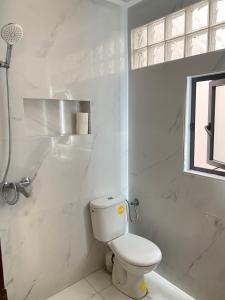 a white bathroom with a toilet and a shower at Agadir City Appartement in Agadir +28 photos