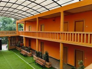 an orange building with benches in a courtyard at P'almshore Ecr' Resort in Mahabalipuram +20 photos