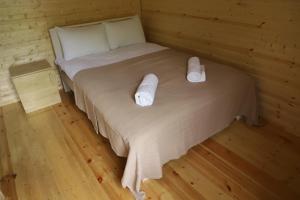 a bedroom with a bed with two white towels on it at Hotel - Old Ushguli in Ushguli