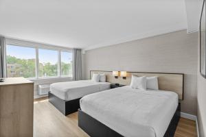 a hotel room with two beds and a window at Ramada Plaza by Wyndham Montreal in Montreal +52 photos