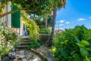 a garden with a stairway leading to a house at Casa Naima: Family House | Terrace & Peaceful Location - Happy Rentals in Breno +25 photos