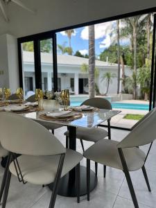 a dining room with a table and chairs and a pool at White House River Manor in Upington