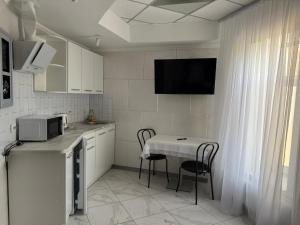 a kitchen with a table with chairs and a microwave at Міні-готель RANDEVU in Zhytomyr +8 photos