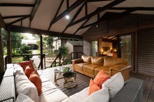 a living room with a couch and chairs on a deck at Sand River Guest House in Johannesburg