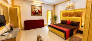 a bedroom with a bed and a flat screen tv at P'almshore Ecr' Resort in Mahabalipuram