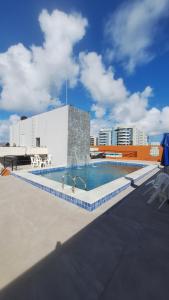 a swimming pool on the roof of a building at Estúdio Ibiza em Jatiúca in Maceió