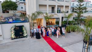 a group of people standing on a red carpet in front of a building at WG Hotel Lake View in Ksamil +180 photos