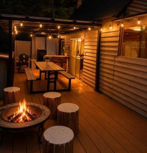 a deck with a fire pit and a table and stools at Kozakura Cottage II in Hamamatsu