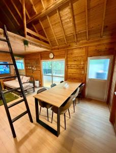 a dining room with a table and chairs and a bed at Kozakura Cottage II in Hamamatsu