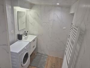 a white bathroom with a washing machine and a sink at chic apartment and zen in Chauray