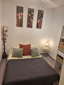 a bed in a room with paintings on the wall at chic apartment and zen in Chauray