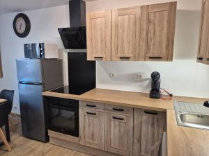 a kitchen with wooden cabinets and a stainless steel refrigerator at chic apartment and zen in Chauray