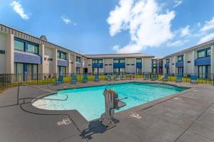 a swimming pool with chairs in front of a building at Red Lion Inn & Suites Kansas City in Kansas City