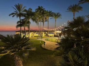 a park with palm trees and the ocean at night at Chalet 1BR 1BA with Beach&Pool&Tennis&Basketball in Jounieh