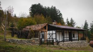 a small cabin in a field with a stone wall at Zartak cottage in Dilijan