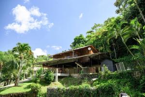 a house on a hill with palm trees at Naranjito River Retreat Events & Groups Sleeps 13 in Naranjito