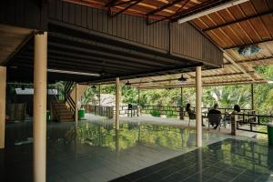 a pavilion with people sitting at tables in the water at Naranjito River Retreat Events & Groups Sleeps 13 in Naranjito