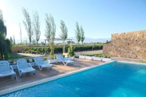a swimming pool with chairs and a gazebo at Rincon del Malbec 3 in Ciudad Lujan de Cuyo