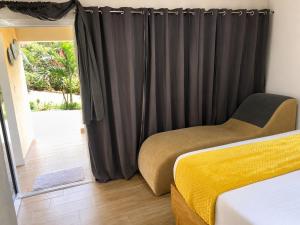 a bedroom with a bed and black curtains at Villas Don Che, 2 villas in Jarabacoa