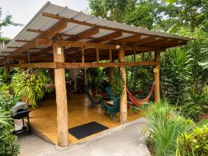 a wooden pergola with a hammock in a garden at Villas Don Che, 2 villas in Jarabacoa