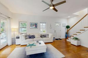 a living room with a white couch and a ceiling fan at Sunny Side Up in Oak Bluffs
