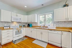 a kitchen with white cabinets and white appliances at Sunny Side Up in Oak Bluffs +29 photos
