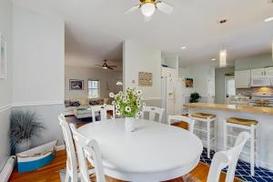 a kitchen and dining room with a white table and chairs at Sunny Side Up in Oak Bluffs