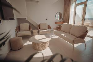 a living room with chairs and a couch and a table at IONEO Dhermi in Dhërmi +131 photos