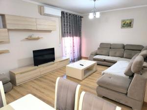 a living room with a couch and a flat screen tv at Astir Apartments in Tirana