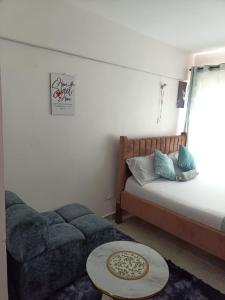 a living room with a couch and a bed at Le Kirstel Suites in Kiambu