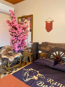 a bedroom with a bed and a tree with pink flowers at Casa Rústica com piscina in Cascavel +72 photos