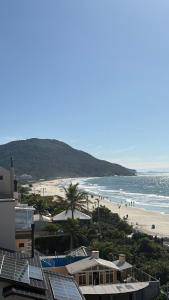 a view of a beach with people in the water at Palm Beach Apart Hotel - Pé na Areia in Florianópolis