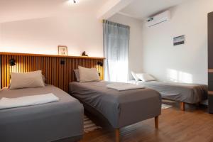 a bedroom with two beds and a window at Velora apartments in Subotica