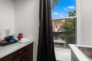 a kitchen with a window and a counter with a sink at Bonjour Plateau Hotel in Montreal +104 photos